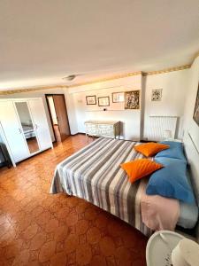 1 dormitorio con 1 cama con almohadas de color naranja y azul en La casa di Anita, en Civita Castellana