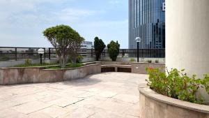 een patio met een bank en bomen en gebouwen bij Perfect Loft with stunning view in San Isidro in Lima