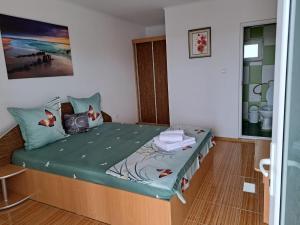 a bedroom with a bed with a green comforter at Casa EliAndrei in 2 Mai