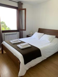 1 dormitorio con 1 cama grande y 2 toallas. en Camping Santa Elena en Mutriku