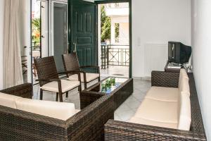 a living room with wicker chairs and a tv on a balcony at Kefalonia, Lixouri family friendly house & parking in Lixouri