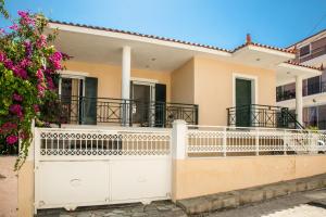 a house with a white fence and flowers at Kefalonia, Lixouri family friendly house & parking in Lixouri