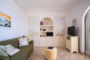 a living room with a couch and a tv at Dimora Bruno e Rubina (centrale a Capri) in Capri