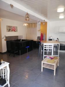 - une cuisine avec une table et des chaises dans la chambre dans l'établissement Ô Temps d'Amour Sauna&Jacuzzi, à Malissard