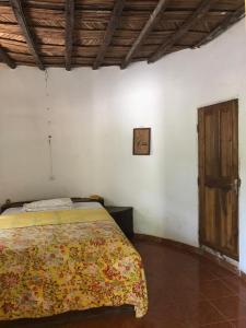 a bedroom with a bed and a wooden door at Karamba Lodge in Kafountine