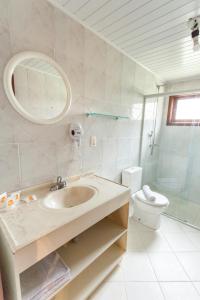 y baño con lavabo, aseo y espejo. en Tri Hotel Lago Gramado en Gramado