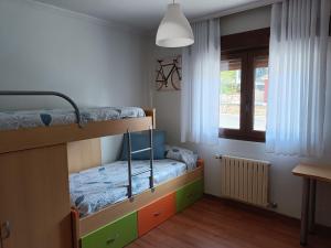 a bedroom with two bunk beds and a window at Casa/chalet en Sanxenxo 3hab. in Sanxenxo