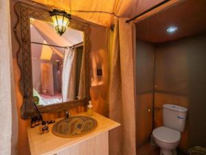 a bathroom with a sink and a mirror at Desert Paradise Luxury Camp in Merzouga +76 photos