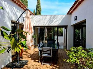 eine Terrasse mit einem Tisch und Stühlen auf einer Terrasse in der Unterkunft Spacieuse villa, environs 10 min à pied des plages in La Garde