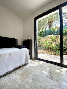 Schlafzimmer mit einem Bett und einer großen Glasschiebetür in der Unterkunft Spacieuse villa, environs 10 min à pied des plages in La Garde