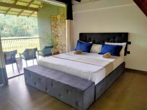 a bedroom with a large bed with blue pillows at Leisure Land in Galle