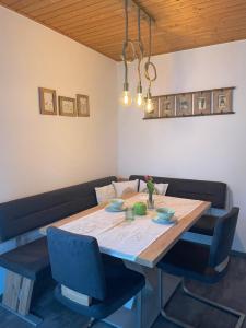 mesa de comedor con 2 sillas azules en Apartments Wrolich en Latschach ober dem Faakersee