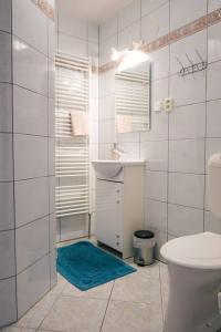 a white bathroom with a sink and a toilet at Apartmány Neronet in Velké Pavlovice