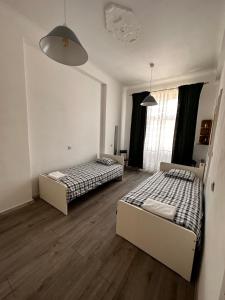 two beds in a room with two windows at Pokoje gościnne na Lwowskiej in Warsaw