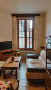 ein Wohnzimmer mit einem Sofa und einem Tisch in der Unterkunft Maison proche Zoo de Beauval in Poulaines