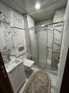 a bathroom with a shower and a toilet and a sink at XANTHOS APART HOTEL Midyat Merkezde in Midyat