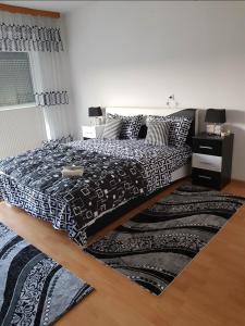 een slaapkamer met een bed met een zwart-wit dekbed bij Ferienwohnung Sabina in Bosanska Krupa