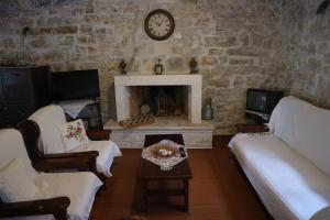 a living room with a stone wall with a fireplace at Reset cottage in Velianitátika