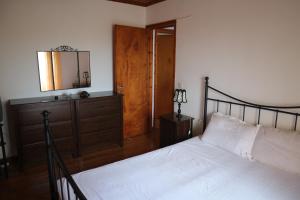 a bedroom with a bed and a dresser and a mirror at Reset cottage in Velianitátika