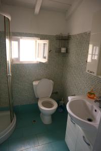 a bathroom with a toilet and a sink at Reset cottage in Velianitátika +4 photos