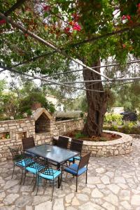 a table and chairs sitting next to a tree at Reset cottage in Velianitátika