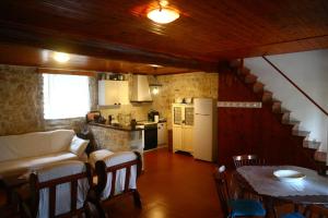 a living room with a table and a kitchen at Reset cottage in Velianitátika