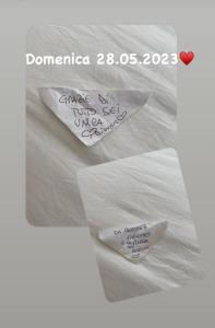 dois pedaços de papel sentados em cima de uma cama em B&B Dionea em Santa Maria di Castellabate