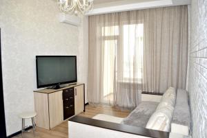 uma sala de estar com uma televisão e um sofá em Апартаменты на Марсельской, Кадорр, 4я Жемчужина em Odessa