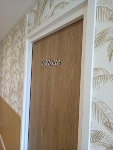 une porte en bois avec le mot de départ inscrit sur elle dans l'établissement Appartement Détente au Cœur du Cotentin, à Valognes