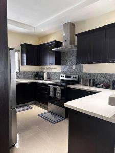 a kitchen with black cabinets and white counter tops at Casa Bella Vista @ Pyramid Point in Ocho Rios