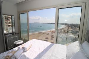 亞歷山大的住宿－Mamoura Private Beach, Exclusive Luxury & Comfort，一间卧室配有一张床,享有海滩美景
