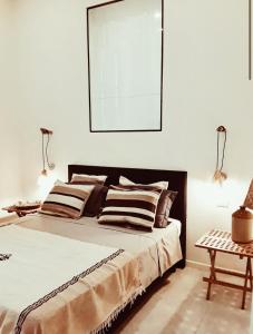 カリアリにあるLa Maison Boheme by Fra Cielo e Mareのベッドルーム1室(大型ベッド1台、ランプ2つ付)