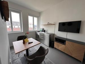 a living room with a table and a kitchen at Rilke Apartments in Linz