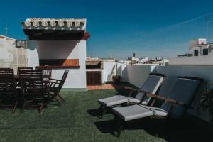 un grupo de sillas sentadas en un techo en Gran casa con piscina centro de sevilla Vistas, en Sevilla