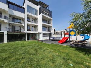 a apartment building with a playground in the yard at MIANELLY Apartments Mamaia Nord in Mamaia Nord