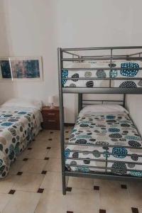 1 dormitorio con 2 literas y suelo de baldosa en Gran casa con piscina centro de sevilla Vistas, en Sevilla