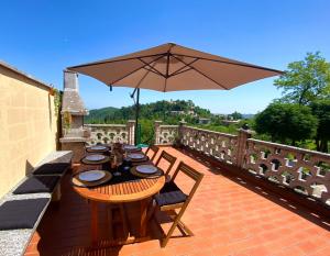 um pátio com uma mesa e um guarda-chuva em CASA BARBERA Terrazza sul Monferrato em Serralunga di Crea