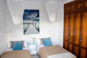 a bedroom with two beds and a picture of a pier at Ático con piscina junto catedral de Sevilla in Seville