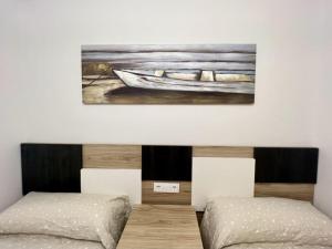 馬爾皮卡的住宿－Öspede Lara Malpica de Bergantiños-Costa da Morte，一间卧室配有两张床,还有一幅小船画