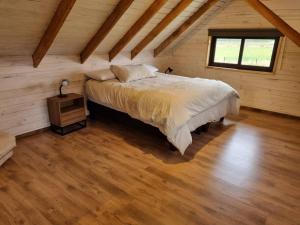 a bedroom with a bed and a window in a attic at Espectacular casa en Frutillar in Frutillar