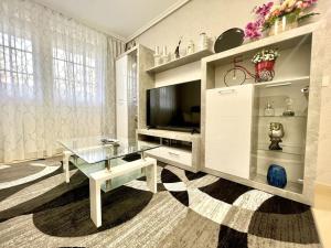 a living room with a glass table and a television at Öspede Lara Malpica de Bergantiños-Costa da Morte in Malpica