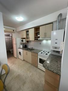 a kitchen with white appliances and a counter top at Gerbera Colorada HAEDO in Mariano J. Haedo
