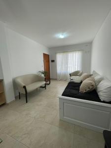 a bedroom with a bed and a couch in it at Gerbera Colorada HAEDO in Mariano J. Haedo