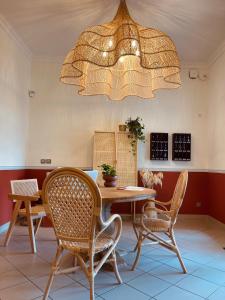 une salle à manger avec une table, des chaises et un lustre dans l'établissement Hôtel Michelet Plage, à Soulac-sur-Mer