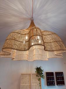 un grande lampadario pendente di metallo appeso a un soffitto di Hôtel Michelet Plage a Soulac-sur-Mer