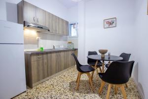 a kitchen with a table and chairs and a refrigerator at Anassa apartments in Asprovalta