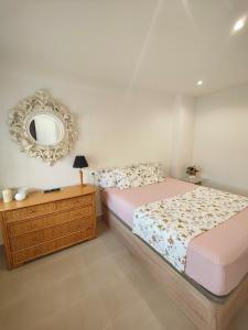 um quarto com uma cama e um espelho na parede em Apartamento vistas al mar de La Pineda! em La Pineda