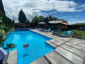 - une piscine avec des chaises et un ballon à l'eau dans l'établissement Dom Wypoczynkowy Zacisze- klimatyczny domek z kominkiem, à Stegna