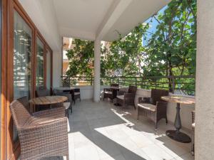 an outdoor patio with tables and chairs and trees at Apartments Butua in Budva