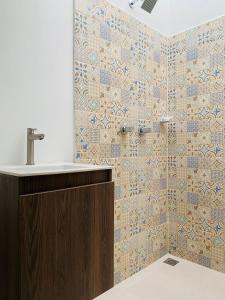 a bathroom with a sink and a tiled wall at Aparta Hotel Mediterráneo Estadio in Medellín
